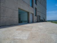 the gray concrete walls of a building have a line of steps on the left side