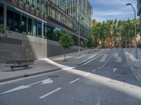 a empty street with a bench in front of the building on one side and an arrow marked out to show direction