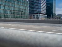 the view from the car window shows traffic on the highway with a building and blue sky in the background