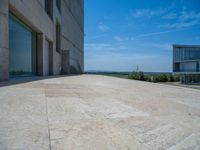 the gray concrete walls of a building have a line of steps on the left side