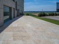 the gray concrete walls of a building have a line of steps on the left side