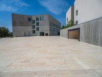 the gray concrete walls of a building have a line of steps on the left side