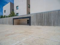 the gray concrete walls of a building have a line of steps on the left side