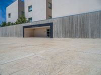 the gray concrete walls of a building have a line of steps on the left side