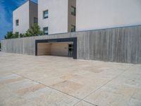 the gray concrete walls of a building have a line of steps on the left side