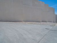 the gray concrete walls of a building have a line of steps on the left side