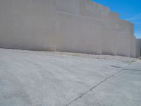 the gray concrete walls of a building have a line of steps on the left side