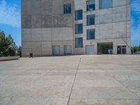 the gray concrete walls of a building have a line of steps on the left side