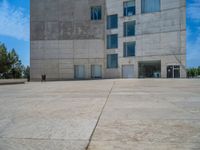 the gray concrete walls of a building have a line of steps on the left side