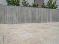 the gray concrete walls of a building have a line of steps on the left side