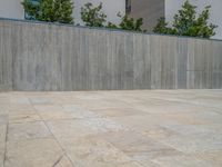 the gray concrete walls of a building have a line of steps on the left side