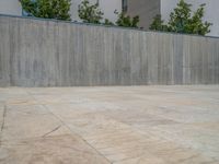 the gray concrete walls of a building have a line of steps on the left side