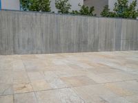 the gray concrete walls of a building have a line of steps on the left side