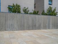 the gray concrete walls of a building have a line of steps on the left side