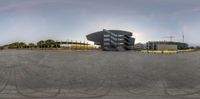 a view from the inside of a fish eye lens shows a building, trees, and blue sky