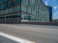 a tall building next to the road in front of it, with windows that open and there are buildings next to it