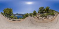 an empty beach with some mountains and trees near it as a fish eye lens appears