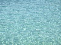 a blue ocean has a boat in the water and waves are moving around it in this photo