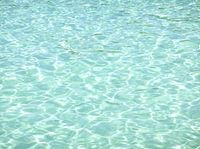a blue ocean has a boat in the water and waves are moving around it in this photo