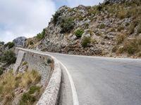 a motorcycle is going by the side of a mountain road on its way to nowhere