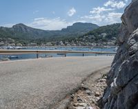 a paved road beside some large boats and a bridge with a bridge to the water