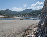 a paved road beside some large boats and a bridge with a bridge to the water