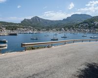 a paved road beside some large boats and a bridge with a bridge to the water