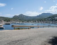 a paved road beside some large boats and a bridge with a bridge to the water