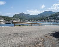 a paved road beside some large boats and a bridge with a bridge to the water