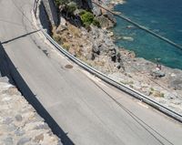 a paved road beside some large boats and a bridge with a bridge to the water