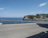 a paved road beside some large boats and a bridge with a bridge to the water