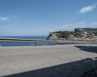 a paved road beside some large boats and a bridge with a bridge to the water