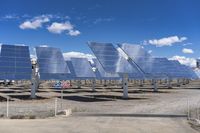 an array of solar panels in a desert field with a flag sign in the middle