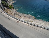 a paved road beside some large boats and a bridge with a bridge to the water