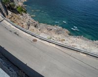 a paved road beside some large boats and a bridge with a bridge to the water