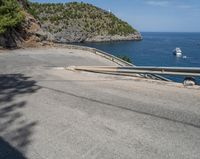 a paved road beside some large boats and a bridge with a bridge to the water