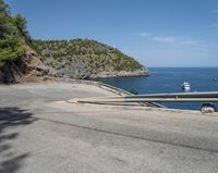 a paved road beside some large boats and a bridge with a bridge to the water