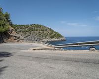 a paved road beside some large boats and a bridge with a bridge to the water