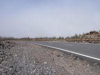 a view from the front seat of a car of a road with rocks around it