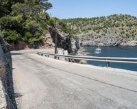 a paved road beside some large boats and a bridge with a bridge to the water