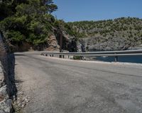 a paved road beside some large boats and a bridge with a bridge to the water