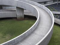 a curved pathway that runs around the perimeter of an indoor building with grass on either side