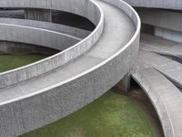 a curved pathway that runs around the perimeter of an indoor building with grass on either side