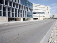 a white building sitting on the side of an empty road next to a highway in front of it