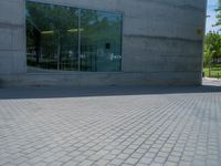 there is a stone wall that reflects the parking area in the window glass at the corner