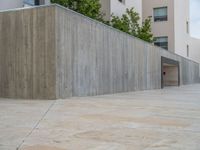 empty area outside concrete building with no people or vehicles at the entrance to area behind it