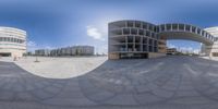 a fish eye lens shot of a plaza and buildings from the street side in a circular panoramic view