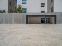 the gray concrete walls of a building have a line of steps on the left side