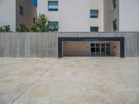 the gray concrete walls of a building have a line of steps on the left side