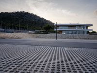 this building is situated on top of a hill next to a paved area where people can walk